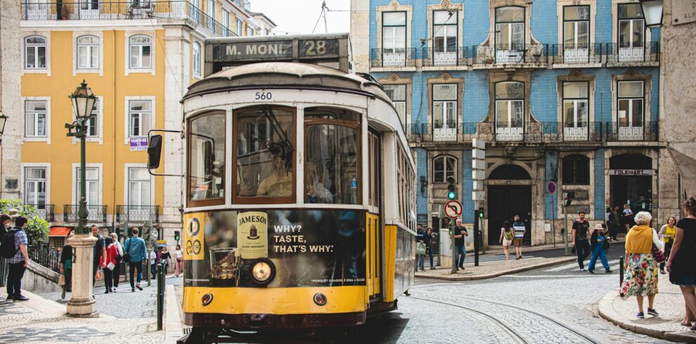 yellow and white tram on road near white concrete building during daytime
