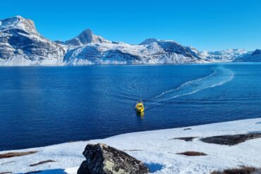 a man in a yellow life jacket is in the water