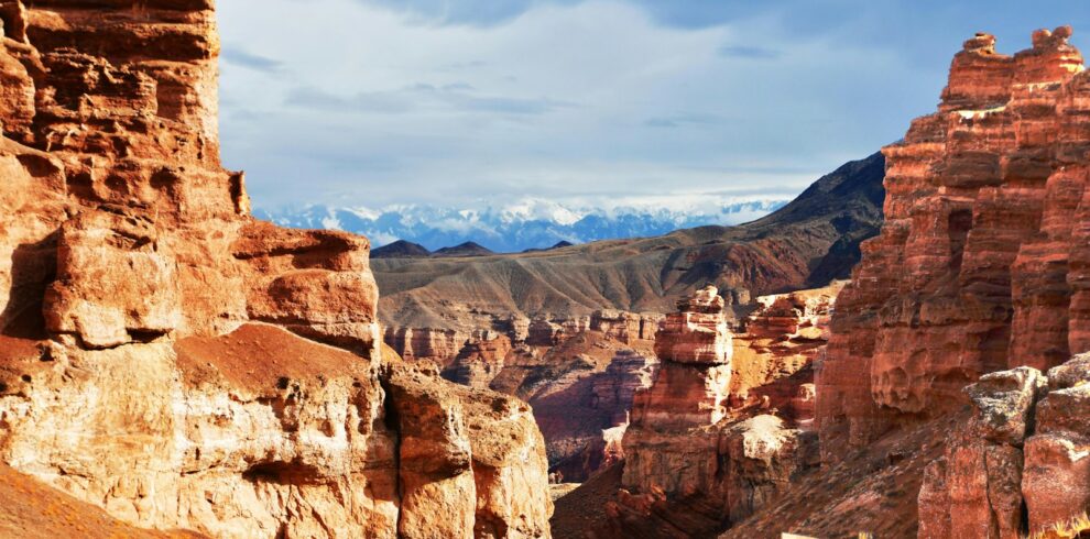 a rocky landscape with mountains in the background